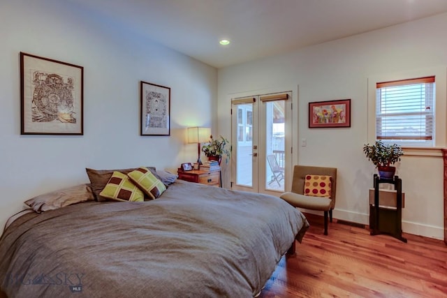 bedroom with access to outside, french doors, and light wood-type flooring