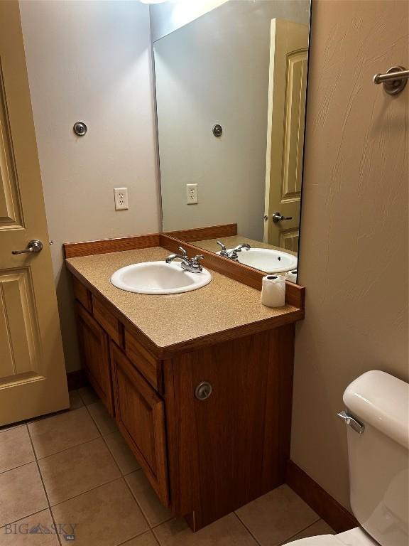 bathroom featuring vanity, tile patterned floors, and toilet