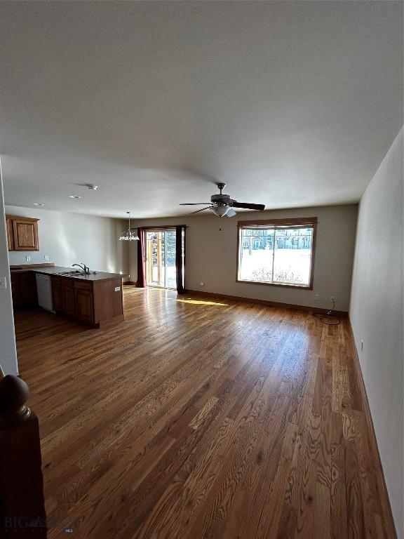 unfurnished living room with sink, dark hardwood / wood-style floors, and ceiling fan