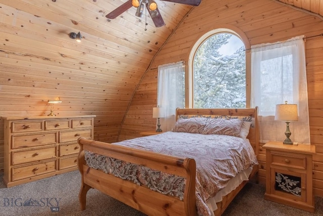 bedroom featuring dark colored carpet, wooden walls, wood ceiling, and ceiling fan