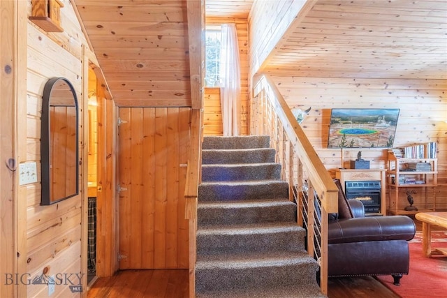 staircase featuring hardwood / wood-style floors, wood ceiling, and wooden walls