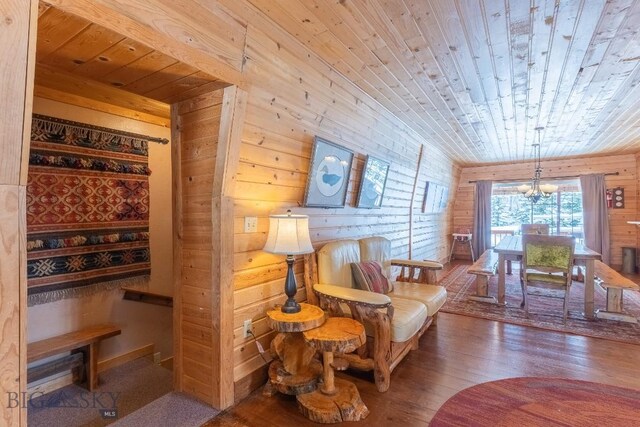 sitting room with an inviting chandelier, wood walls, hardwood / wood-style floors, and wooden ceiling