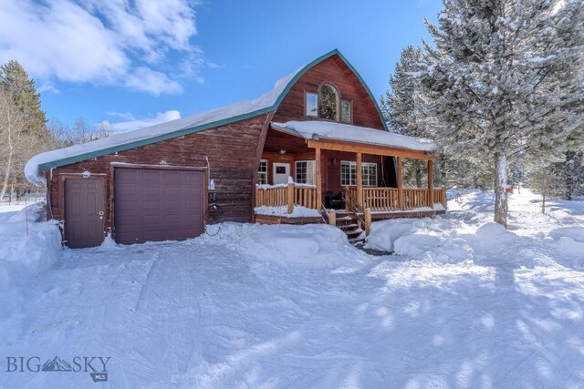 log home with a garage and covered porch