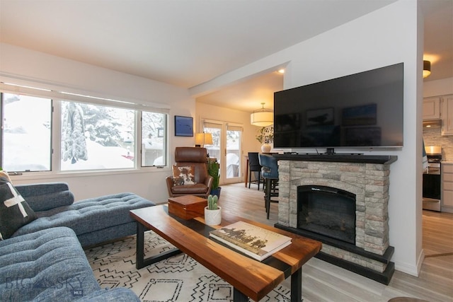 living room featuring a fireplace and light wood-type flooring