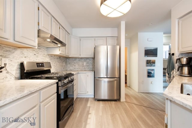 kitchen with tasteful backsplash, stainless steel appliances, light stone counters, and white cabinets