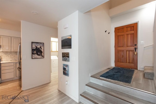 entryway featuring washer / dryer and light hardwood / wood-style flooring