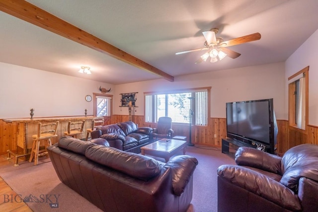 carpeted living room featuring beamed ceiling and ceiling fan