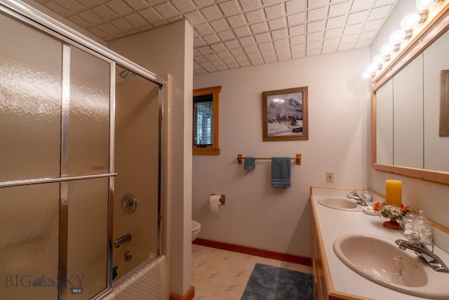 full bathroom featuring vanity, bath / shower combo with glass door, and toilet