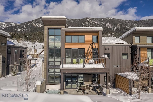 snow covered house featuring a mountain view