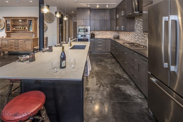 2174 Little Coyote Rd, Big Sky, MT 59716 - kitchen with appliances with stainless steel finishes, wall chimney range hood, tasteful backsplash, a spacious island, and light stone countertops