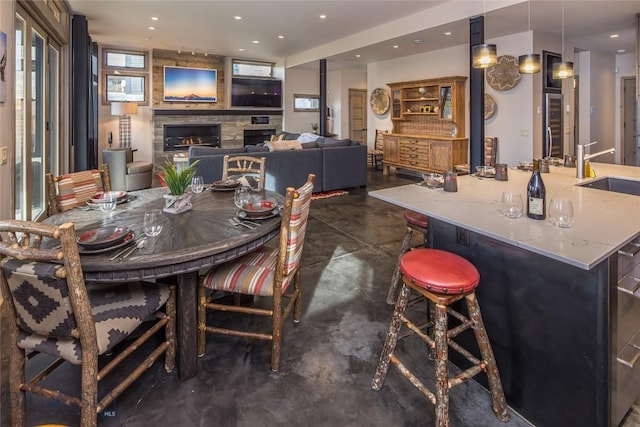 2174 Little Coyote Rd, Big Sky, MT 59716 - dining space with concrete flooring, a fireplace, recessed lighting, and a bar