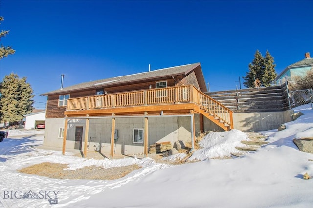 snow covered property featuring stairway and a wooden deck