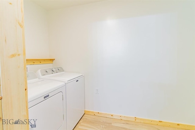 washroom with light wood-style floors, laundry area, and washing machine and clothes dryer