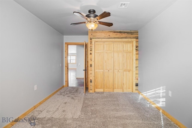 carpeted bedroom with a closet, visible vents, ceiling fan, and baseboards