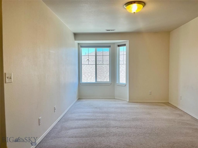 unfurnished room featuring light carpet