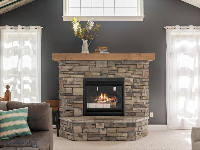 details with a stone fireplace and carpet