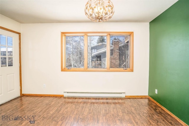 entrance foyer with a baseboard radiator, hardwood / wood-style floors, and a notable chandelier