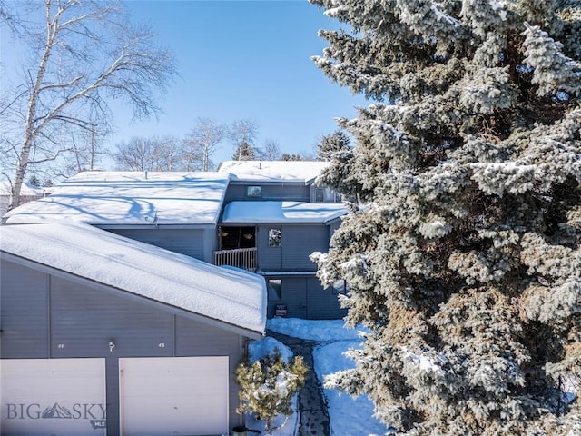 snow covered property featuring a garage