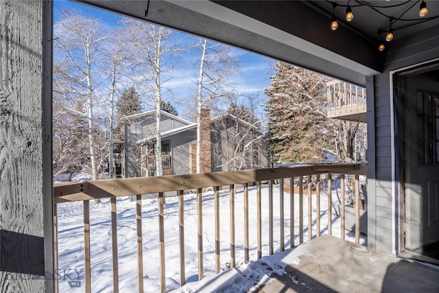 view of snow covered back of property