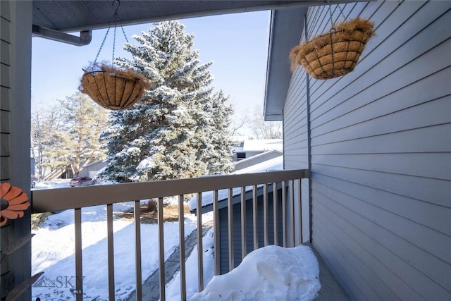 view of snow covered back of property