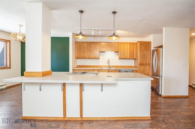 kitchen with stainless steel appliances, hanging light fixtures, sink, and dark hardwood / wood-style flooring