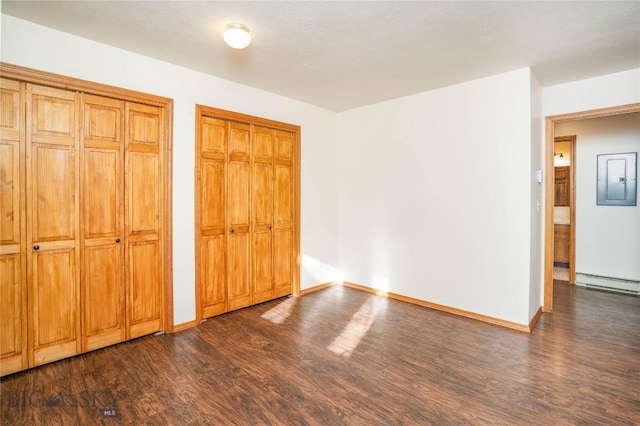 unfurnished bedroom featuring dark wood-type flooring and two closets