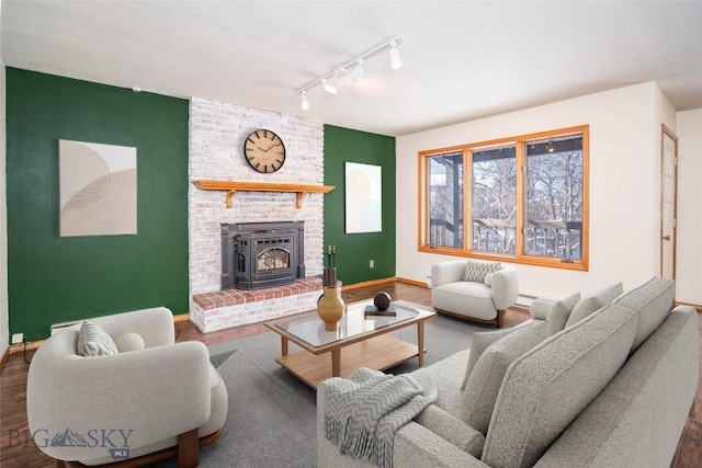 living room with a baseboard heating unit, rail lighting, dark hardwood / wood-style floors, and a fireplace