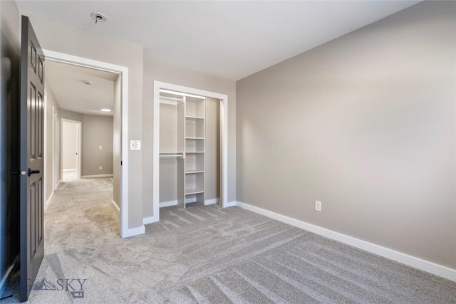 unfurnished bedroom with light colored carpet and a closet