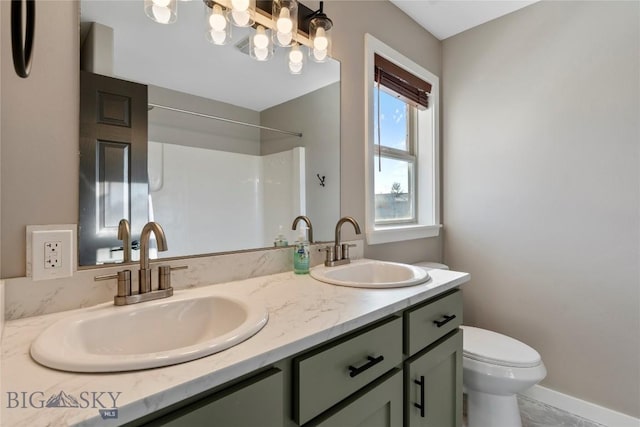 bathroom with vanity, toilet, and a shower