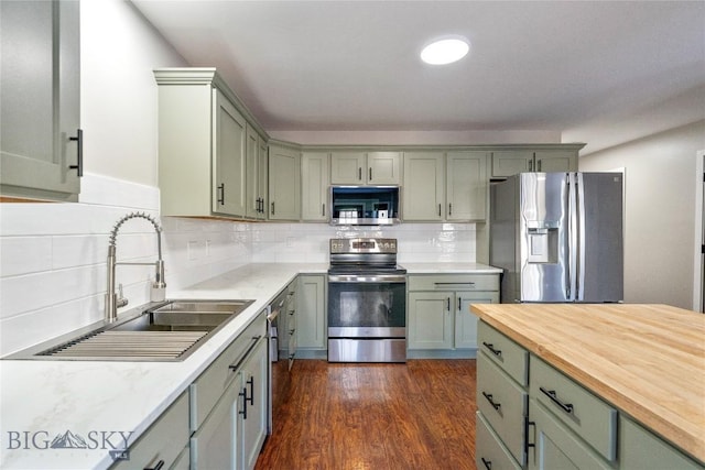 kitchen featuring dark hardwood / wood-style flooring, sink, decorative backsplash, and stainless steel appliances