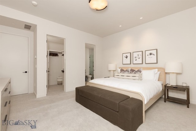 carpeted bedroom featuring a spacious closet and connected bathroom