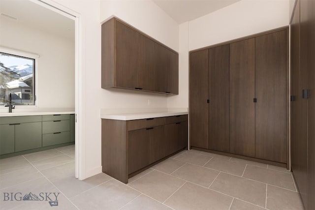 kitchen featuring dark brown cabinetry and light tile patterned floors