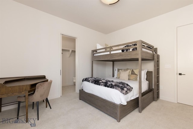 bedroom featuring a spacious closet and light colored carpet