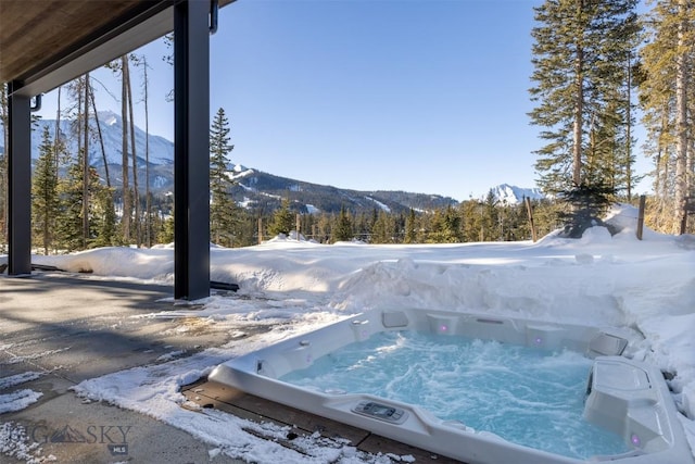 exterior space with an outdoor hot tub and a mountain view