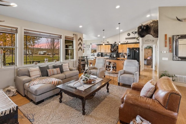 living room featuring vaulted ceiling and light hardwood / wood-style flooring