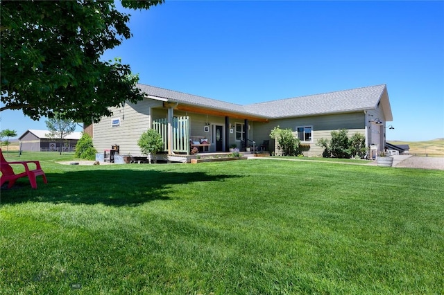 rear view of property featuring a lawn