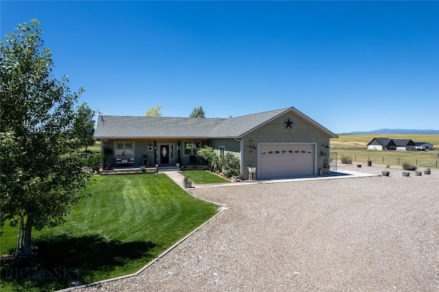 ranch-style home featuring a garage, covered porch, and a front lawn