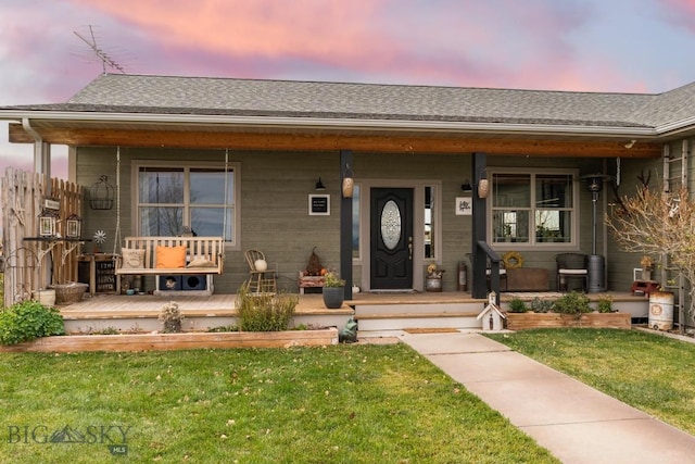 view of front of property with covered porch and a lawn