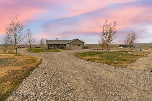 ranch-style home featuring a rural view and a garage