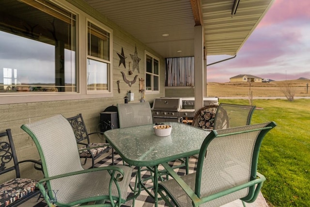 patio terrace at dusk with a yard and grilling area