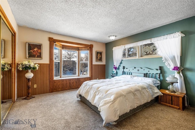 carpeted bedroom featuring a closet, a textured ceiling, and wood walls