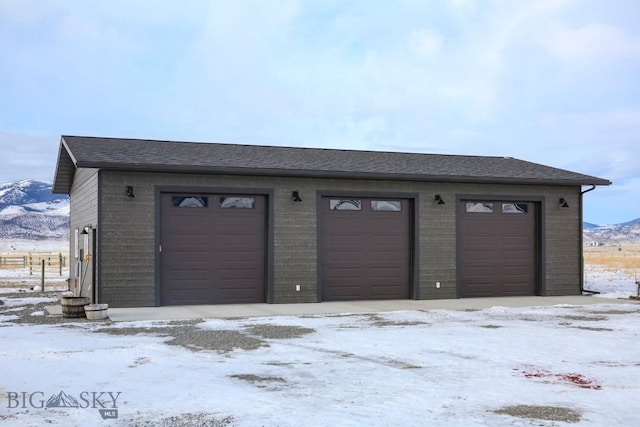 snow covered garage with a mountain view