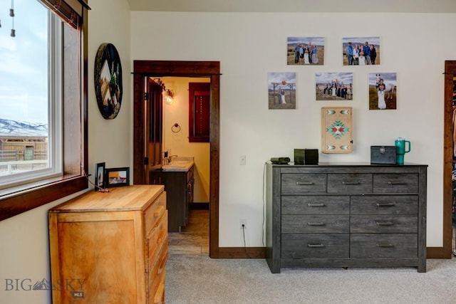 hall featuring sink and light colored carpet