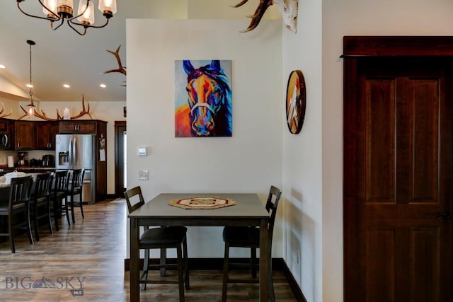 dining area featuring an inviting chandelier and dark hardwood / wood-style floors