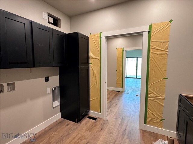 6111 Springhill Rd, Belgrade, MT 59714 - kitchen featuring dark cabinets, light wood finished floors, and baseboards