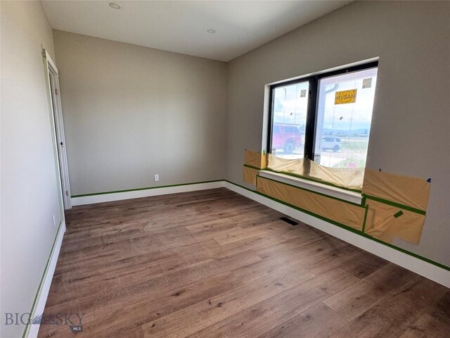 6111 Springhill Rd, Belgrade, MT 59714 - unfurnished room featuring wood finished floors, baseboards, and a baseboard heating unit