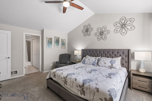 carpeted bedroom featuring lofted ceiling, connected bathroom, and ceiling fan