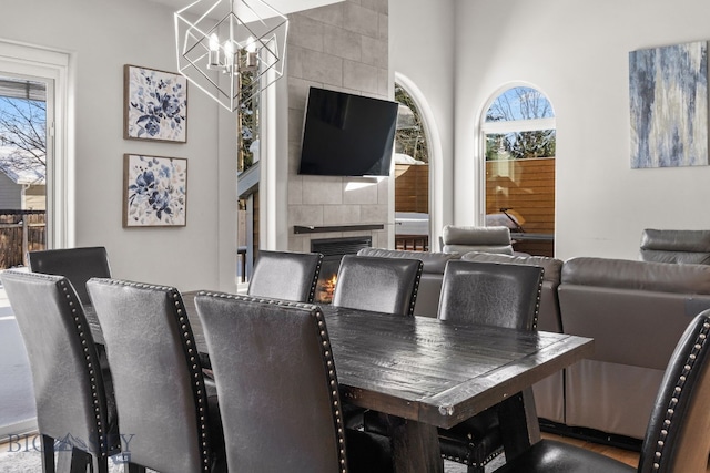 dining space with an inviting chandelier and a fireplace