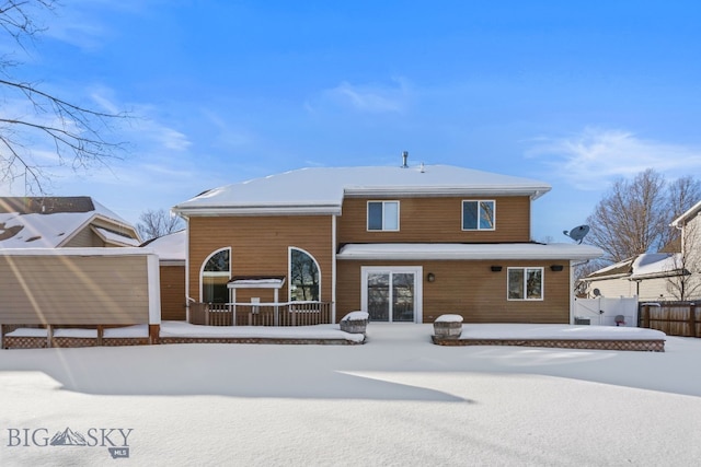 view of snow covered rear of property