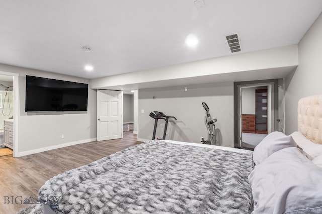 bedroom featuring ensuite bathroom and hardwood / wood-style floors